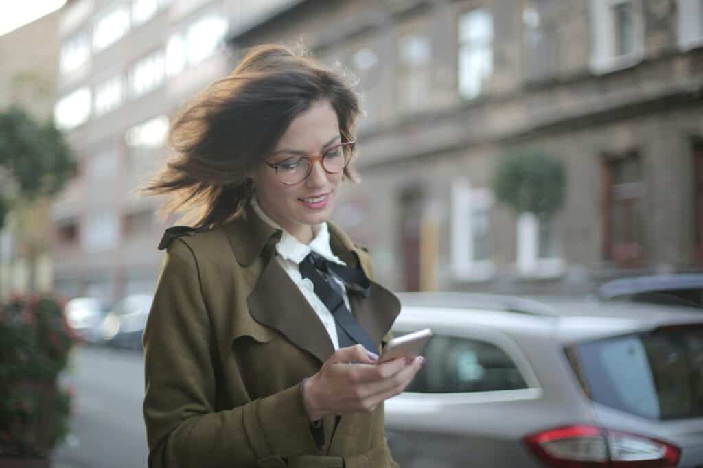 A woman is using her phone to access Transport for London app