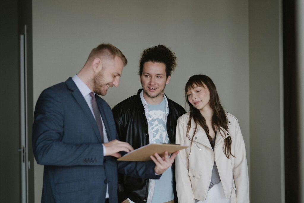 A couple speaking with an estate agent inside a vacant flat