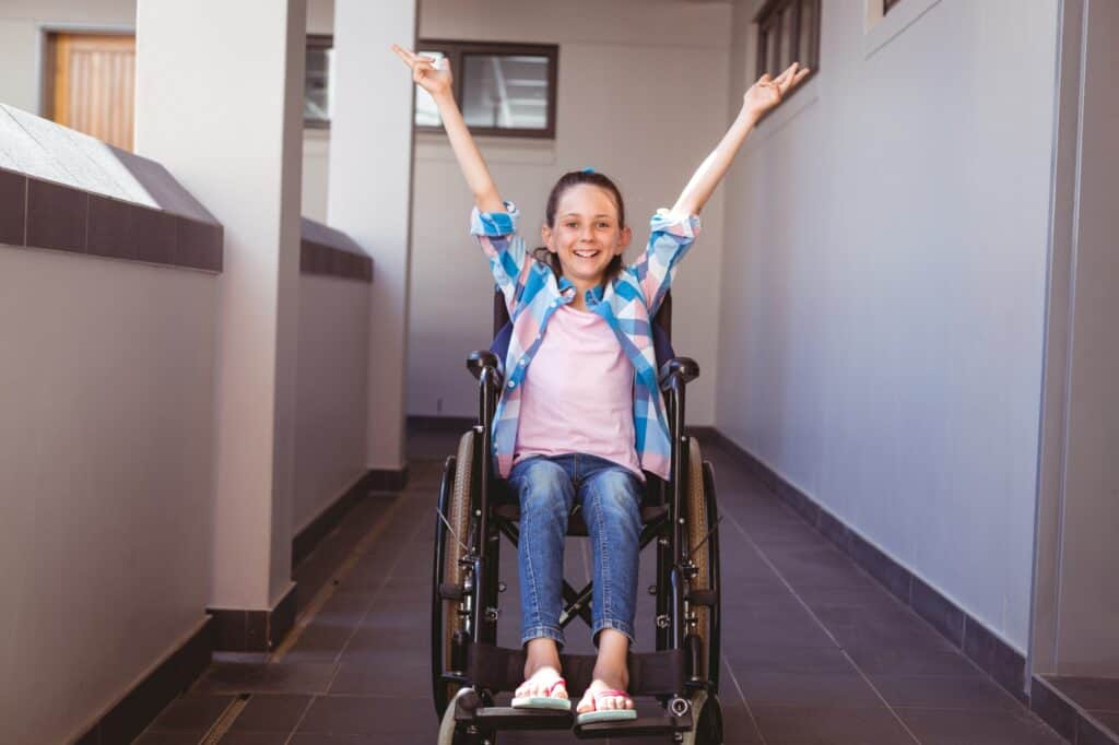 A girl in a wheelchair in front of a flat