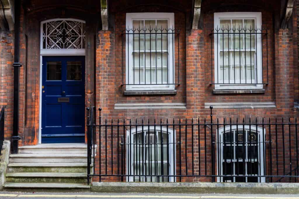 A brick house with blue door in the concept of 'best affordable housing options in Wimbledon'.