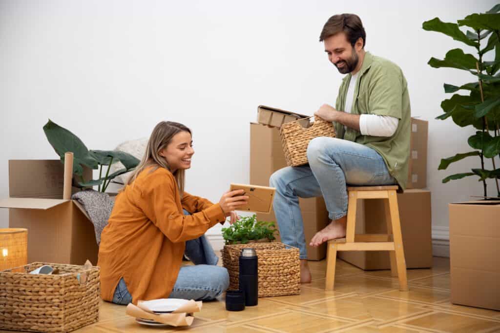 A young couple happily unpacking in their new flat